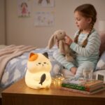 Veilleuse chat kawaii en silicone souple tenant un poisson Gribouille allumée - Rituel Dodo