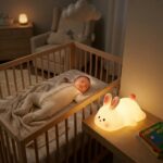 Veilleuse lapin allongé blanc et orange en silicone souple Lapinou-Cocon allumée - Rituel Dodo