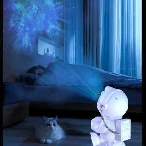 Ambiance nuit calme avec veilleuse projecteur astronaute galaxie bleue et aurore boréale dans une chambre d'enfant.